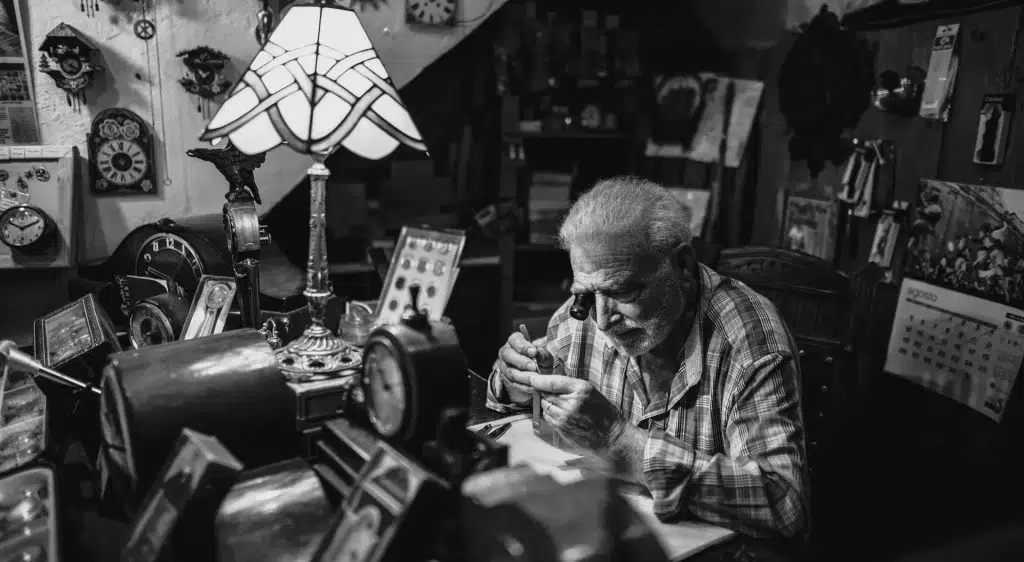 Retrato de relojero trabajando en su taller en blanco y negro. Fotografía de autor de Joan Boira, Barcelona
